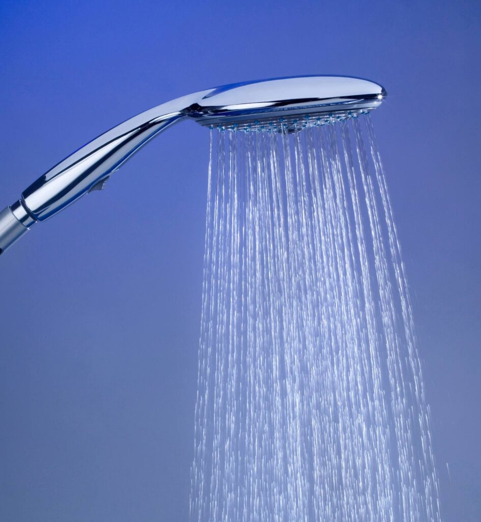 Silver running showerhead in front of a blue background.