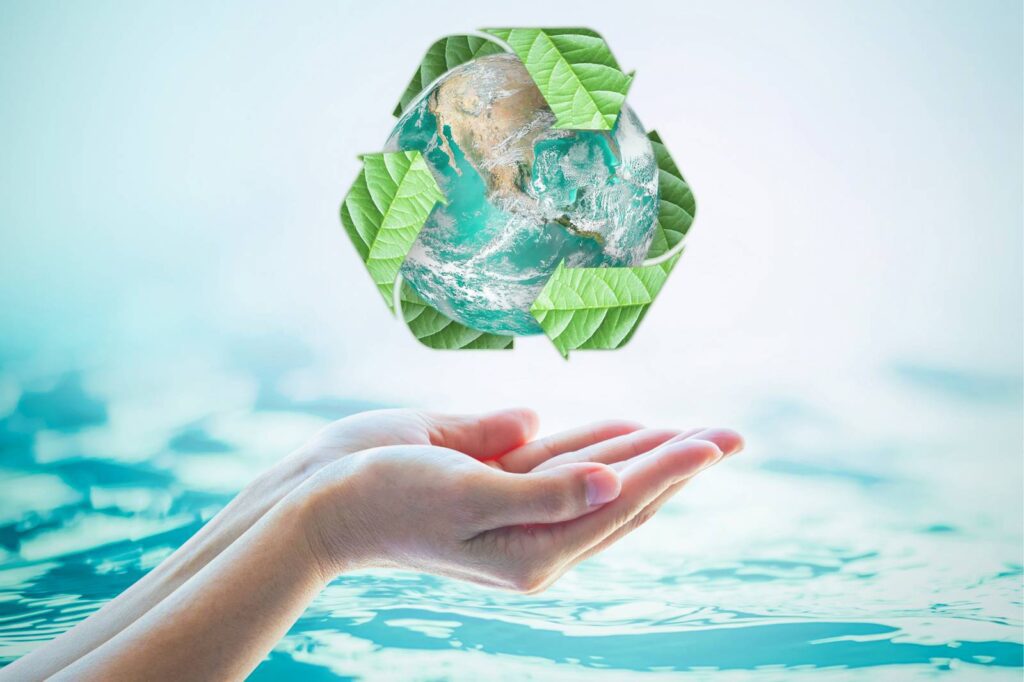 Hands reaching out below a graphic of the earth with green recycling symbol around it, against a blue water background.